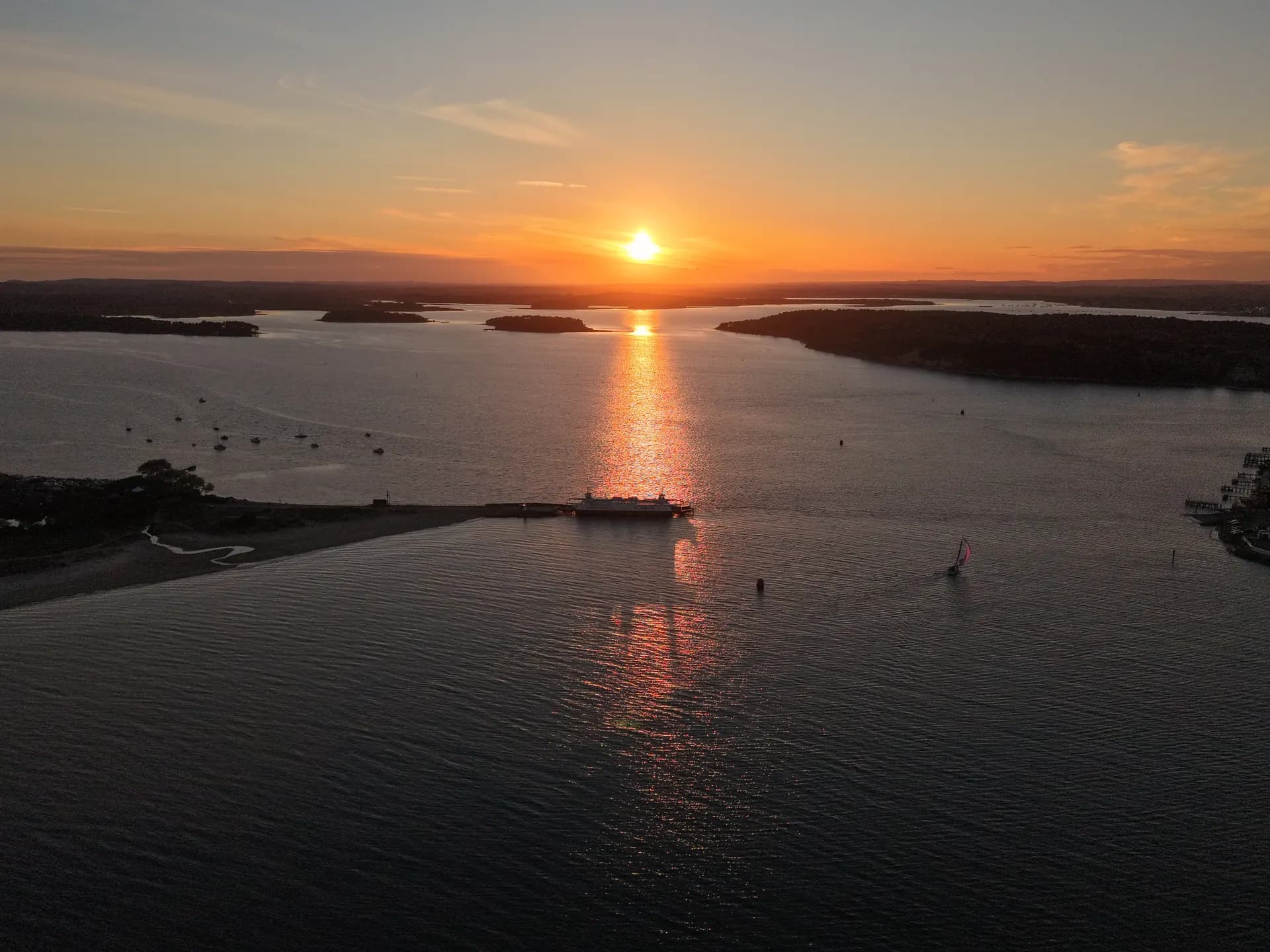 Aerial view of the Sandbanks chain ferry at sunset across the harbour entrance