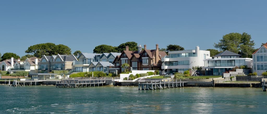 Contemporary waterside houses along the Sandbanks shoreline overlooking Poole Harbour